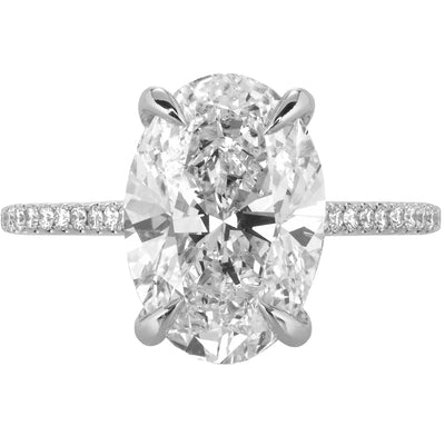 Image of oval diamond engagement ring set with claw prongs featuring a hidden halo with pave diamond band in white gold | Buchroeders Jewelers